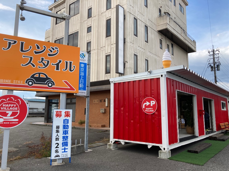 車屋さんの敷地内にある赤いコンテナが Happy Village 7 ツクツク グルメ 投稿型グルメデーターベース